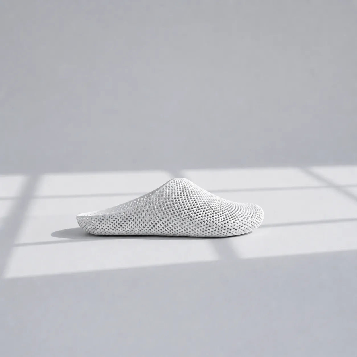 EASE 01 3D printed house slipper —  showing fine mesh lattice upper and minimal sole